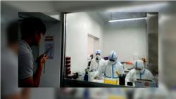 Cambodian medical personnel dressed in protective gear perform coronavirus testing in a lab. (Courtesy of Cambodia's Communicable Disease Control Department)