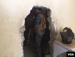 Across West Mosul, homes have holes in the walls that IS militants forced families to make so they could travel from house to house without being seen by airstrikes. Soldiers now use them in the areas they've captured to avoid IS snipers. June 23, 2017, in Mosul, Iraq. (H. Murdock/VOA)
