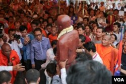 ព្រះ​សង្ឃ​និង​ប្រជាពលរដ្ឋ​រំកិលរូប​សំណាក​ស្ពាន់​តំណាង​លោក​កែម ឡី​អ្នក​វិភាគ​កិច្ច​អភិវឌ្ឍន៍​សង្គម​ដែល​ត្រូវ​ខ្មាន់​កាំ​ភ្លើង​បាញ់​ស្លាប់ ដែល​ត្រូវ​បាន​ហែរ​ចេញ​ពី​រាជធានី​ភ្នំពេញ​ទៅ​កាន់​ស្រុក​កំណើត​លោក​នៅ​ខេត្ត​តាកែវ នៅ​ថ្ងៃ​អាទិត្យ ទី​១៧ ខែ​តុលា ឆ្នាំ២០១៦។ (ឡេង ឡែន/VOA)