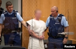Brenton Tarrant, charged for murder in relation to the mosque attacks, is lead into the dock for his appearance in the Christchurch District Court, New Zealand, March 16, 2019. (Suspect's face blurred at source)