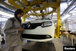 FILE - A female employee works in a Renault factory in Oran, west of Algiers, Nov. 10, 2014.