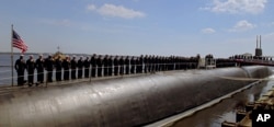 FILE - The crew of the U.S. Navy's nuclear-powered submarine USS Georgia stand at attention on the stern of the sub at Naval Submarine Base Kings Bay, Ga., March 28, 2008.