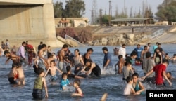 រូបឯកសារ៖ មនុស្ស​នាំ​គ្នា​ហែល​ទឹក​នៅ​ទន្លេ Euphrates ក្នងុ​ពេល​អាកាស​ធាតុ​ក្ដៅ នៅ​ទីក្រុង​ Raqqa ប្រទេស​ស៊ីរី កាល​ពី​ខែ​ឧសភា ២០១៩។