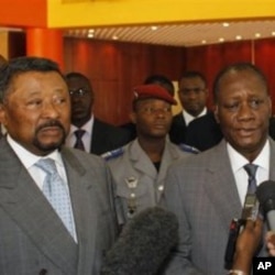 Ivory Coast's internationally-recognized President, Alassane Ouattara, right, addresses journalists following a meeting with African Union commission chairman Jean Ping, left, at the Golf Hotel in Abidjan, Ivory Coast, March 5, 2011