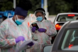 Medical technicians work at a drive-through coronavirus disease (COVID-19) testing facility at the Regeneron Pharmaceuticals company's Westchester campus in Tarrytown, New York, U.S. September 17, 2020