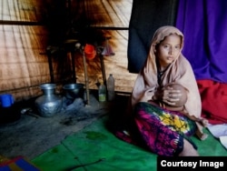 Pregnant Rohingya refugee Sitara Begum, 14, holding her 7-month-old baby, was married off in Myanmar when she was 13. (Photo by Noor Hossain)