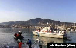 Protesters at Mytilini harbor on Lesbos hold a banner between two boats that reads “Ferries Are for Safe Passage, Not for Deportation,” as a Greek coast guard vessel approached and its crew ordered the protesters to move, April 4, 2016.