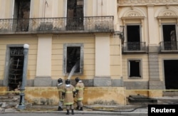 Firefighters spray water on the National Museum of Brazil after a fire in Rio de Janeiro, Brazil Sept. 4, 2018.