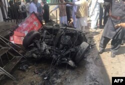 FILE - Pakistani security officials and residents gather at the site of a powerful explosion at a market in Parachinar, capital of the Kurram tribal district, on March 31, 2017.