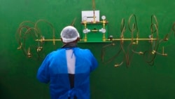 A health worker stands in front of an empty oxygen tank station, the only station at Joventina Dias Hospital, a small clinic in Manaus, Brazil.