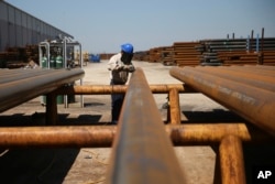 Jose Mata grinds a steel pipe at the Borusan Mannesmann plant in Baytown, Texas, April 23, 2018. President Donald Trump extended tariff exemptions on aluminum and steel exports from the European Union, Canada and Mexico late on April 30, 2018.