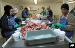 Employees, many from Laos and Thailand, crack crab shells for up to 12 hours a day in Bayou La Batre, Alabama.