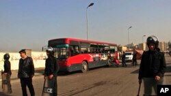 Egyptian police stand guard after an explosion has hit a public bus in Cairo's eastern Nasr City district, Dec. 26, 2013.