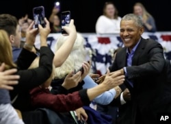 FILE - Former President Barack Obama, right, greets Democratic supporters at Genesis Convention Center in Gary, Ind., Nov. 4, 2018. Obama rallied Democrats on behalf of Senator Joe Donnelly.