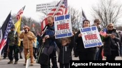 واشنگٹن ڈی سی میں کرونا سے بچاؤ کے سلسلے میں عائد ویکسین لگوانے اور ماسک پہننے سمیت دیگر پابندیوں کے خلاف مظاہرہ۔