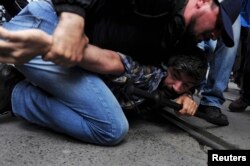 FILE - A plainclothes police officer detains a demonstrator during a protest in central Istanbul, May 31, 2014. Protesters were marking the one-year anniversary of major anti-government demonstrations.