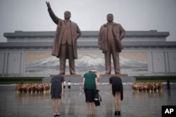 27일 한국전 정전협정 64주년을 맞아 평양 만수대 언덕을 찾은 북한 주민들이 김일성·김정일 동상에 절하고 있다.