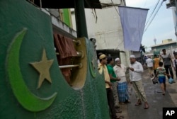 Muslim men gather outside a mosque in Colombo, Sri Lanka, April 26, 2019. Sri Lanka’s president has appealed to the island nation not to view its minority Muslim community as terrorists in the wake of Easter attacks that officials say were carried out by Muslim extremists.