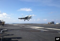 An FA-18 jet fighter takes off on the USS John C. Stennis aircraft carrier in the South China Sea on April 15, 2016.