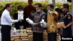FILE - Indonesian President Joko Widodo (C) and other officials prepare to destroy illegal narcotics during an event in Jakarta, Indonesia, Dec. 6, 2016.