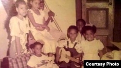 Jessi Calzado-Esponda (center) is seen at home in Cuba before she left as an accidental refugee at the age of seven. (J. Soh/VOA)