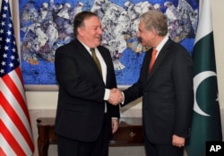 In this photo released by Pakistan's Press Information Department, visiting U.S. Secretary of State Mike Pompeo, left, shakes hand with Pakistan's Foreign Minister Shah Mahmood Qureshi, prior to their meeting in Islamabad, Pakistan, Sept. 5, 2018.