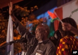 Roch Marc Christian Kabore, left, winner of Burkina Faso's presidential election, celebrates as supporters gather outside his campaign headquarters in Ouagadougou, Dec. 1, 2015.