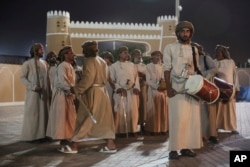 In this July 31, 2017 file photo, a group of dancers wait to perform a sword-dance during the annual summer monsoon festival in Salalah, Oman.