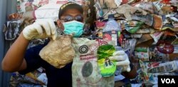 Petugas Bea Cukai Tanjung Perak Surabaya menunjukkan sampah popok dan kemasan plastik yang jadi ikutan sampah kertas asal Australia, 9 Juli 2019 (Foto: Petrus Riski/VOA)