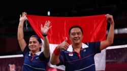 Hary Susanto dan Leani Ratri Oktila dari Indonesia merayakan kemenangan mereka melawan Lucas Mazur dan Faustine Noel dari Prancis di Paralympic Games Tokyo 2020. (Foto: REUTERS/Athit Perawongmetha)