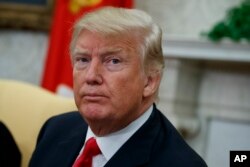 President Donald Trump listens to a question from a reporter in the Oval Office of the White House, April 30, 2018, in Washington.
