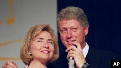 In this June 22, 1994 file photo, President Bill Clinton and first lady Hillary Clinton for supporters in Washington. (AP