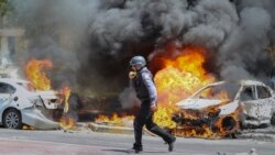 An Israeli firefighter walks next to cars hit by a missile fired from Gaza Strip, in the southern Israeli town of Ashkelon, Tuesday, May 11, 2021.