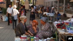 Street vendors talk at a market in Tashkent, Uzbekistan, Wednesday, Aug. 31, 2016. (AP Photo)