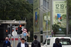 香港立法会选举宣传牌下的行人 (2021年12月15日) 汤惠芸摄