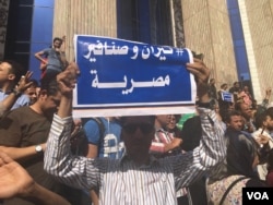 An Egyptian protester holds a sign saying in Arabic “Tiran and Sanafir are Egyptian,” referring to Red Sea islands Egypt plans to cede control of to Saudi Arabia in downtown Cairo, April 15, 2016. (VOA/ H. Elrasam)