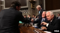 美国陆军部长埃斯珀(Mark Esper)与参议院军委会主席英霍夫(Inhofe)握手（美国之音黎堡2019年7月16日）
