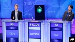 "Jeopardy!" champions Ken Jennings, left, and Brad Rutter, right, look on as IBM's Watson computer beats them to answer a question during a practice round of the "Jeopardy!" quiz show in Yorktown Heights, N.Y., on Jan. 13, 2011. (AP Photo/Seth Wenig)