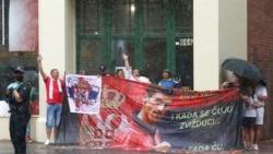 Protesters gather in a rain outside an immigration detention hotel where Serbia's Novak Djokovic is believed to stay, in Melbourne, Australia, Jan. 7, 2022.