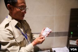 មន្ត្រី​ក្រសួង​សាធារណការ និង​ដឹកជញ្ជូន​កំពុង​ពន្យល់​ណែនាំ​ដល់​ប្រជា​ពលរដ្ឋ​ខ្មែរ ដែល​មក​ប្តូរ​ប័ណ្ណ​បើកបរ​ថ្មី​ នៅ​ឯមណ្ឌល​ប្តូរ​ និង​ពន្យារ​ប័ណ្ណ​បើកបរ​នៅ​ផ្សារ​ទំនើប AEON ក្នុង​រាជធានី​ភ្នំពេញ កាលពី​ថ្ងៃ​ទី​១៥ ខែ​មិថុនា ឆ្នាំ​២០១៦។ (ហ៊ាន សុជាតា/VOA)