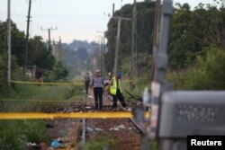Police officers stand at the site where a Boeing 737 plane crashed after taking off from Havana's main airport the previous day, in the agricultural area of Boyeros, Cuba, May 19, 2018.