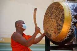 Seorang biksu memukul beduk setelah PM Kamboja Hun Sen memerintahkan agar semua pagoda membunyikan lonceng dan beduk lima kali sehari sebagai pesan untuk melawan COVID-19, di Phnom Penh, Kamboja, 24 Maret 2021. (Foto: REUTERS/Cindy Liu)