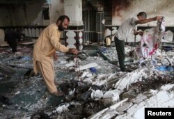 Relatives inspect the damage after an overnight suicide attack at a mosque in Herat, Afghanistan, Aug. 2, 2017.