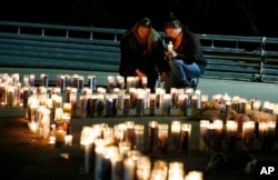 2015年10月1日罗斯伯格居民为乌姆普夸社区大学举行烛光祈祷会后，人们用蜡烛组成了该校的缩写字母，悼念无辜受害的死者。