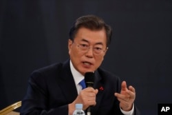 FILE - South Korean President Moon Jae-in answers reporters' question during his New Year news conference at the Presidential Blue House in Seoul, Jan. 10, 2018.