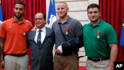 From the left, Anthony Sadler, a senior at Sacramento University in California, French President Francois Hollande, U.S. Airman Spencer Stone, and Alek Skarlatos a U.S. National Guardsman from Roseburg, Oregon pose for a photo.
