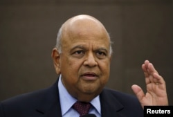 FILE - South Africa's then-Finance Minister Pravin Gordhan reacts during a media briefing in Sandton near Johannesburg, March 14, 2016.