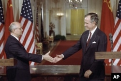 FILE - U.S. President George H.W. Bush, right, and Soviet President Mikhail Gorbachev shake hands following the signing of accords at the White House in Washington, June 1, 1990.