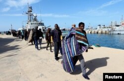 FILE - Migrants arrive at a naval base after they were rescued by the Libyan coast guard in Tripoli, Libya, March 13, 2018.