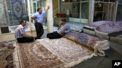 FILE - Iranian merchants wait for customers at a carpet market in Tehran's old main bazaar, in Iran, Aug. 10, 2015. Anger and frustration over the economy has been the main fuel for the surprise eruption of protests that began Dec. 28, 2017.